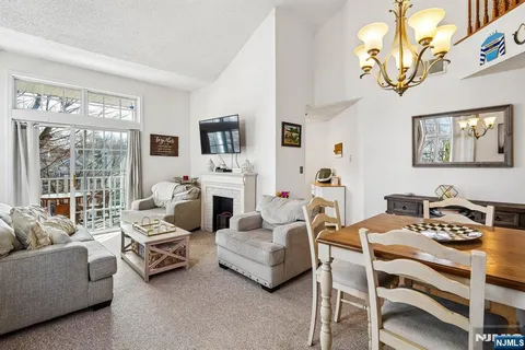 a living room with furniture a fireplace and a large window