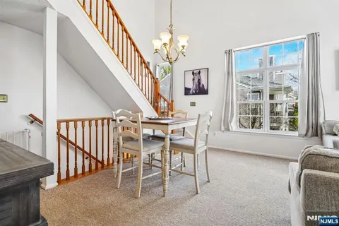 a dining room with wooden floor and stairs