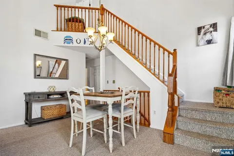 a view of a livingroom with furniture staircase and kitchen view