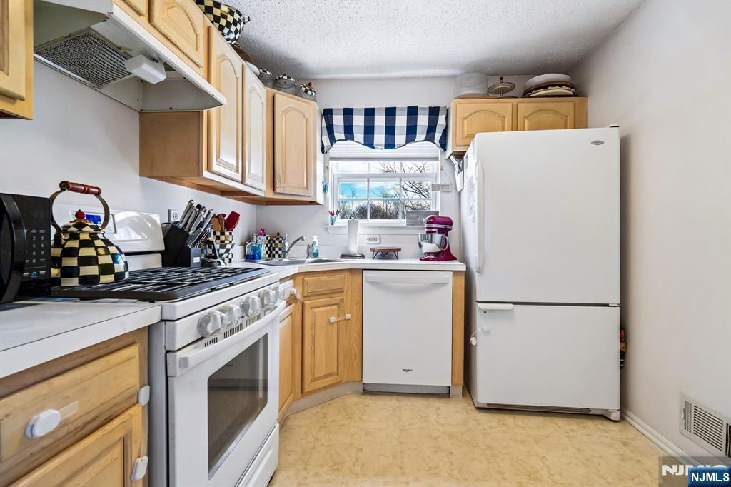 1317 Paddington Road Mahwah, NJ 07430 - Photo 10 of 28 a kitchen with a refrigerator sink stove and cabinets