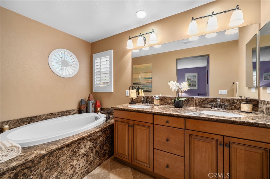4140 Garvey Way Riverside, CA 92501 - Photo 13 of 25 a bathroom with a granite countertop sink mirror and bathtub