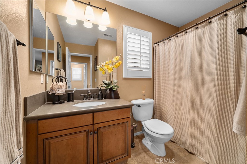 4140 Garvey Way Riverside, CA 92501 - Photo 16 of 25 a bathroom with a toilet a sink and a mirror