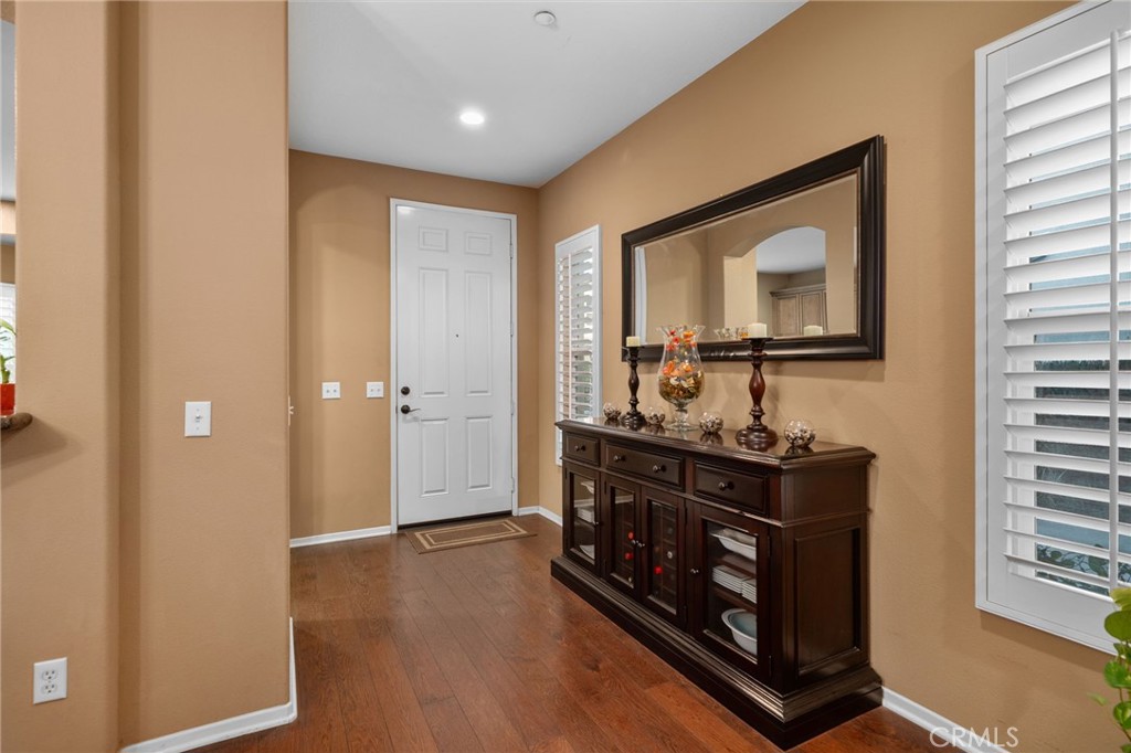 4140 Garvey Way Riverside, CA 92501 - Photo 8 of 25 a hallway with front door wooden floor and windows