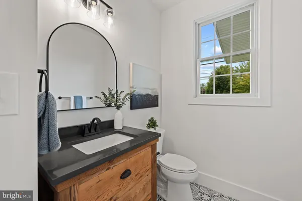 a bathroom with a granite countertop sink a toilet and a mirror