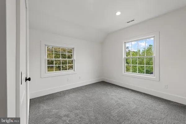 an empty room with windows and closet