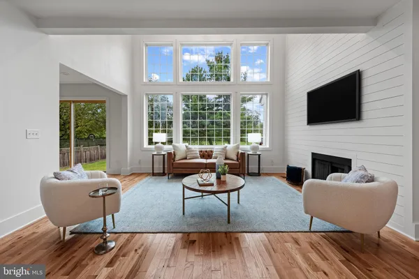 a living room with furniture a fireplace a flat screen tv and a large window
