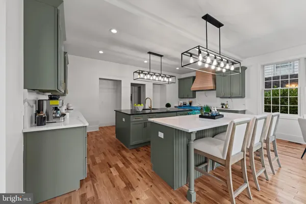 a kitchen with kitchen island granite countertop a sink a center island and cabinets