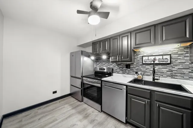 a kitchen with stainless steel appliances granite countertop a sink stove and refrigerator