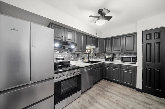 a kitchen with stainless steel appliances granite countertop a stove a refrigerator and a sink