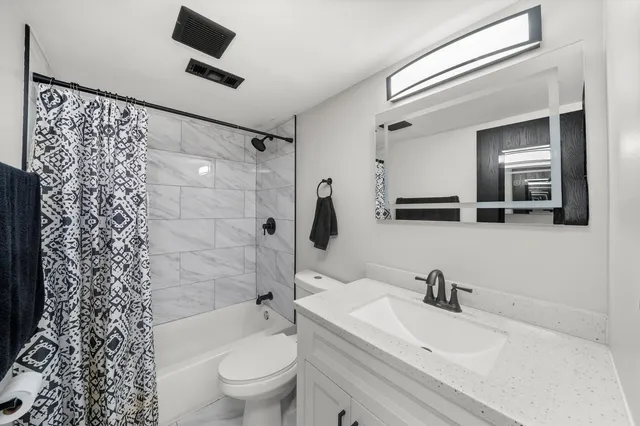 a bathroom with a sink toilet a mirror and shower