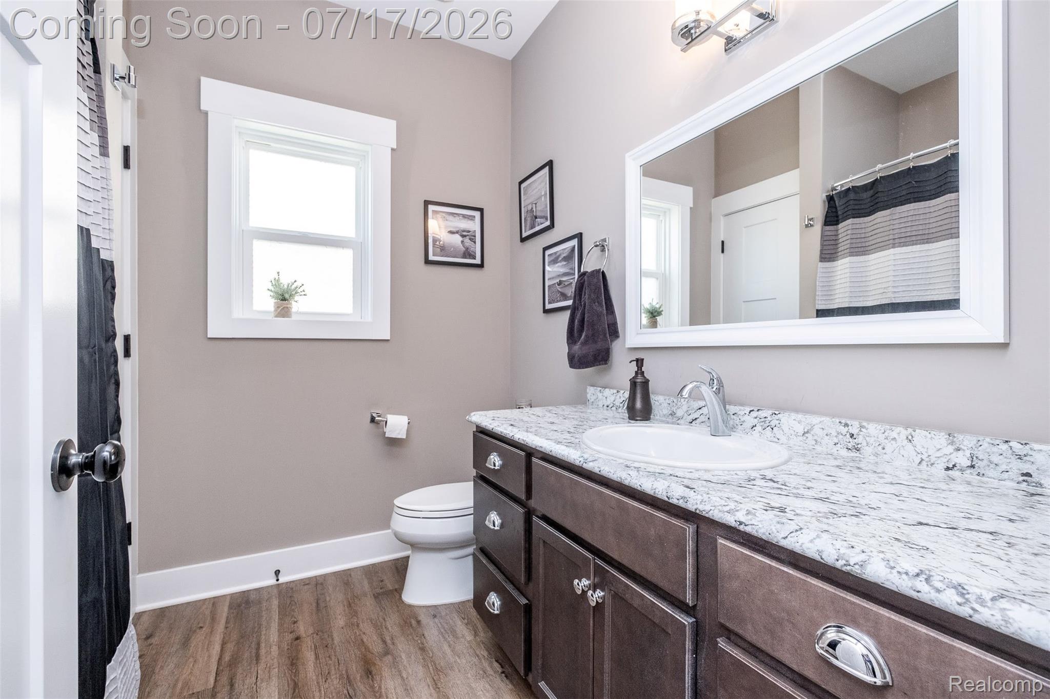 12349 Sugar Maple Drive Fenton, MI 48430 - Photo 33 of 67 Bathroom vanity featuring an integrated sink, granite-style countertop, and dark wood-finish cabinetry with decorative hardware
