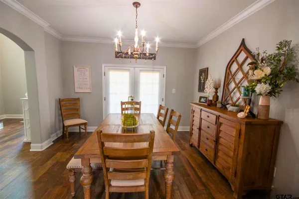 a view of a dining room with furniture a chandelier and wooden floor