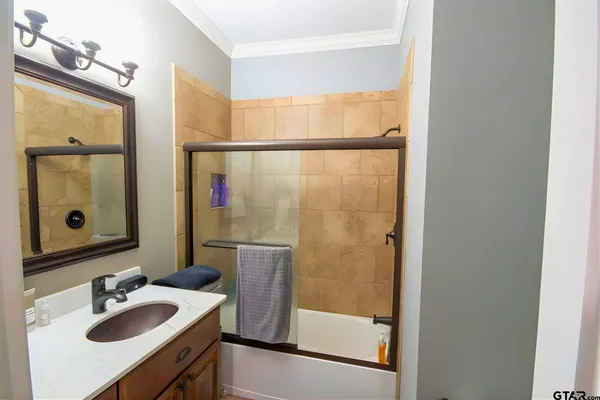 a bathroom with a sink mirror and shower