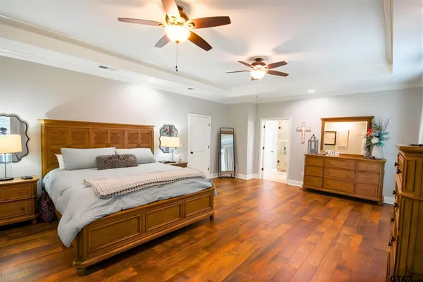a bedroom with a bed chandelier and a window