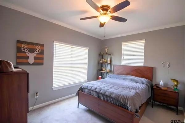 a bedroom with a large bed chandelier and window