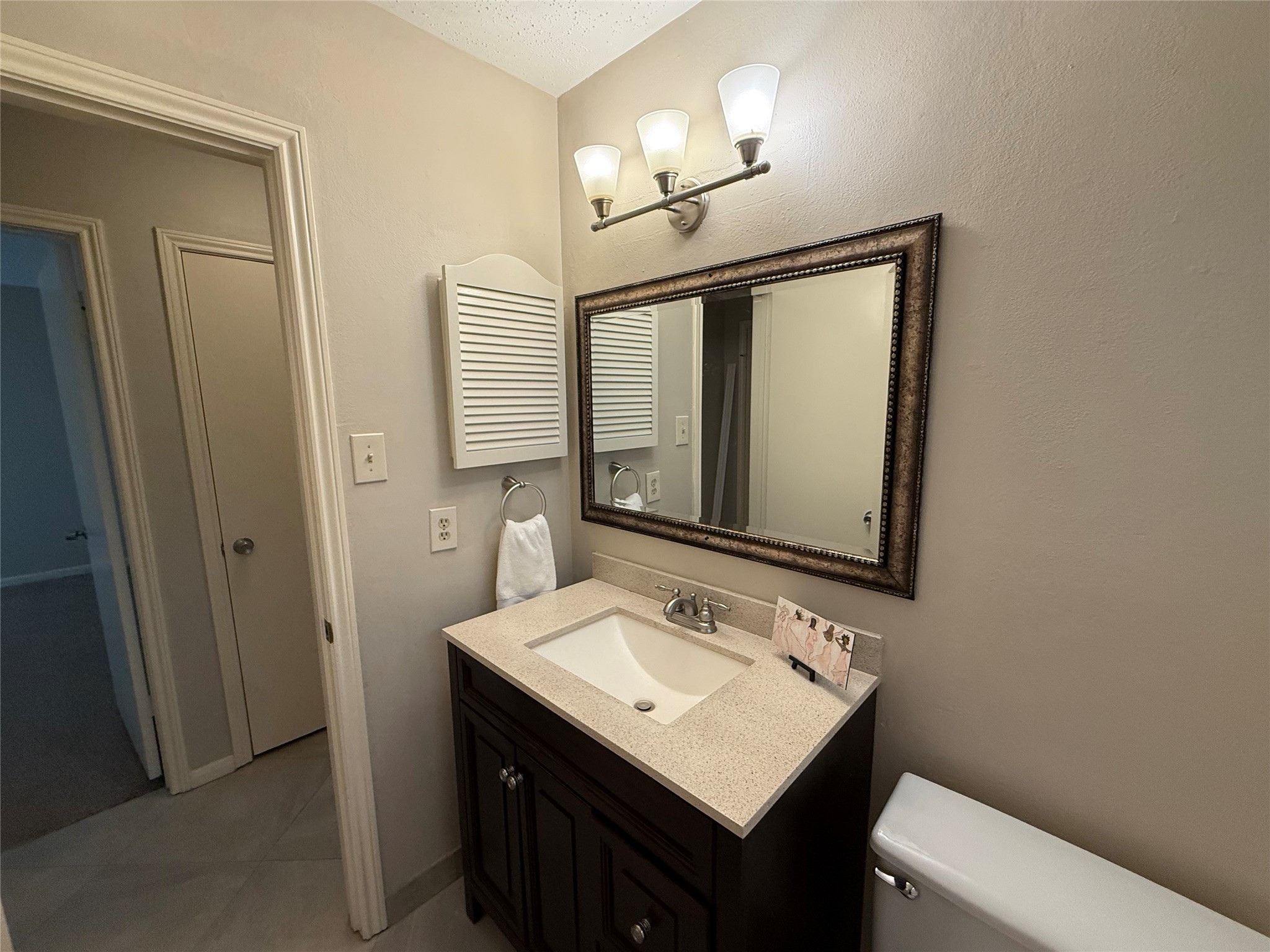 13 Maywind Court The Woodlands, TX 77381 - Photo 24 of 33 Guest bath features large-format porcelain tile, mahogany vanity & refreshed 2026 finishes.