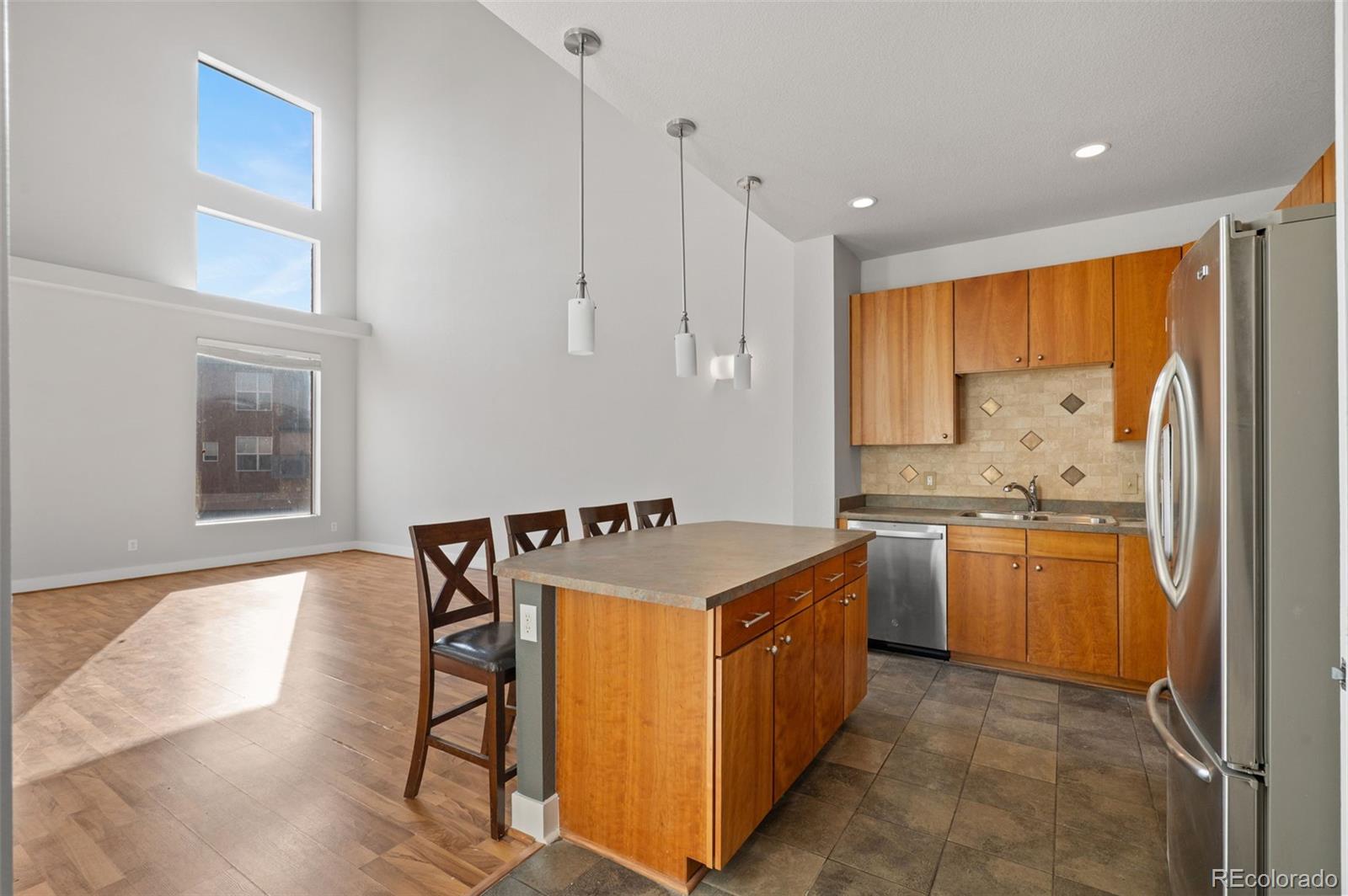 2360 South Wheeling Circle Aurora, CO 80014 - Photo 11 of 31 a kitchen with kitchen island granite countertop a sink counter top space and stainless steel appliances