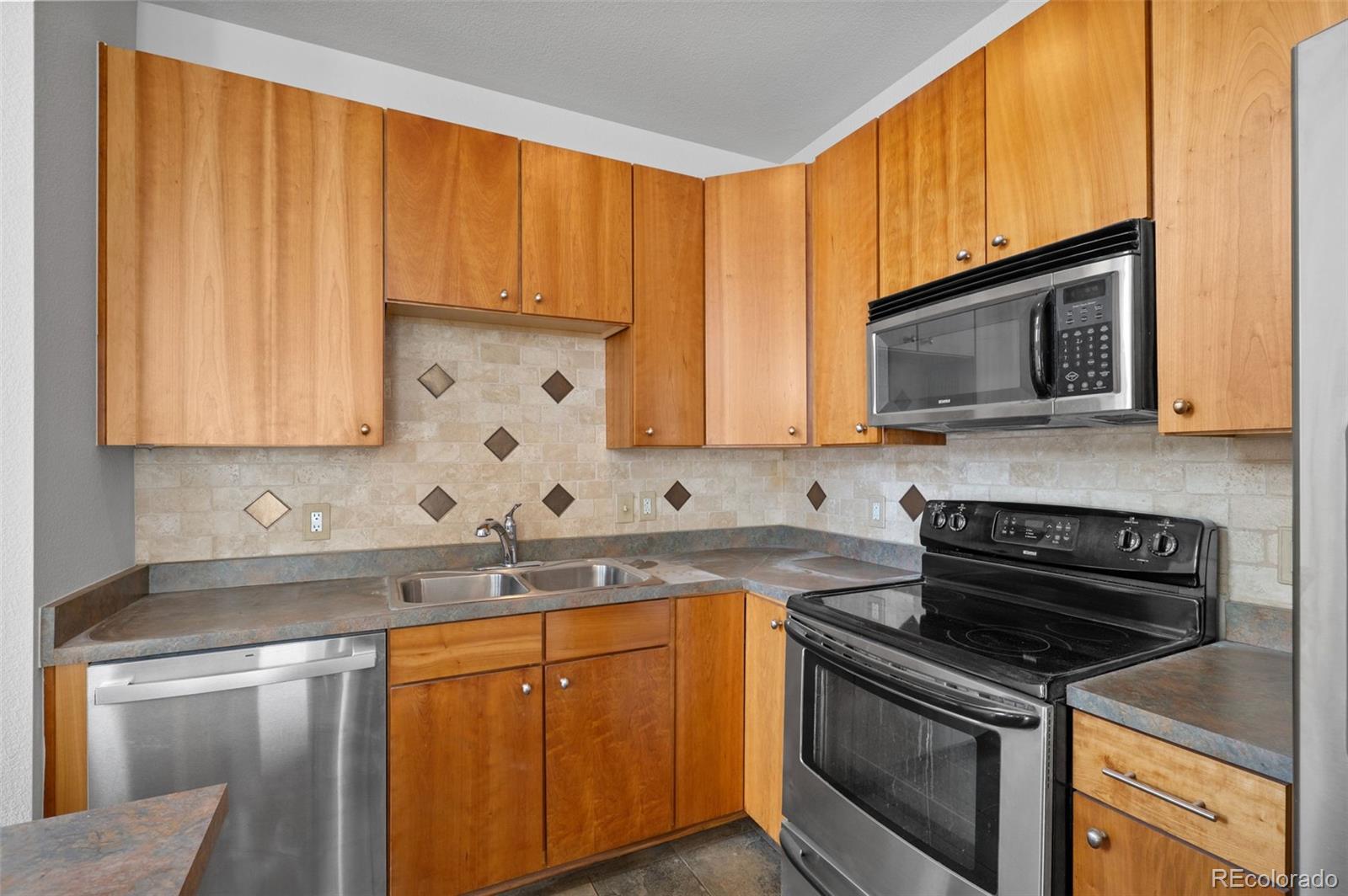 2360 South Wheeling Circle Aurora, CO 80014 - Photo 12 of 31 a kitchen with stainless steel appliances granite countertop a sink stove and microwave