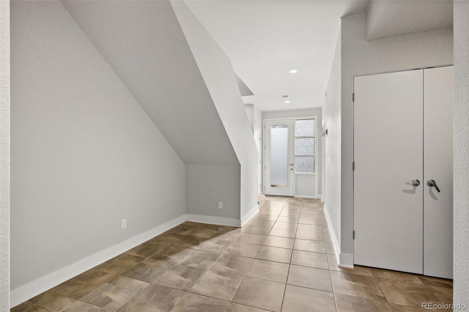2360 South Wheeling Circle Aurora, CO 80014 - Photo 5 of 31 a view of a hallway to an empty room with wooden floor