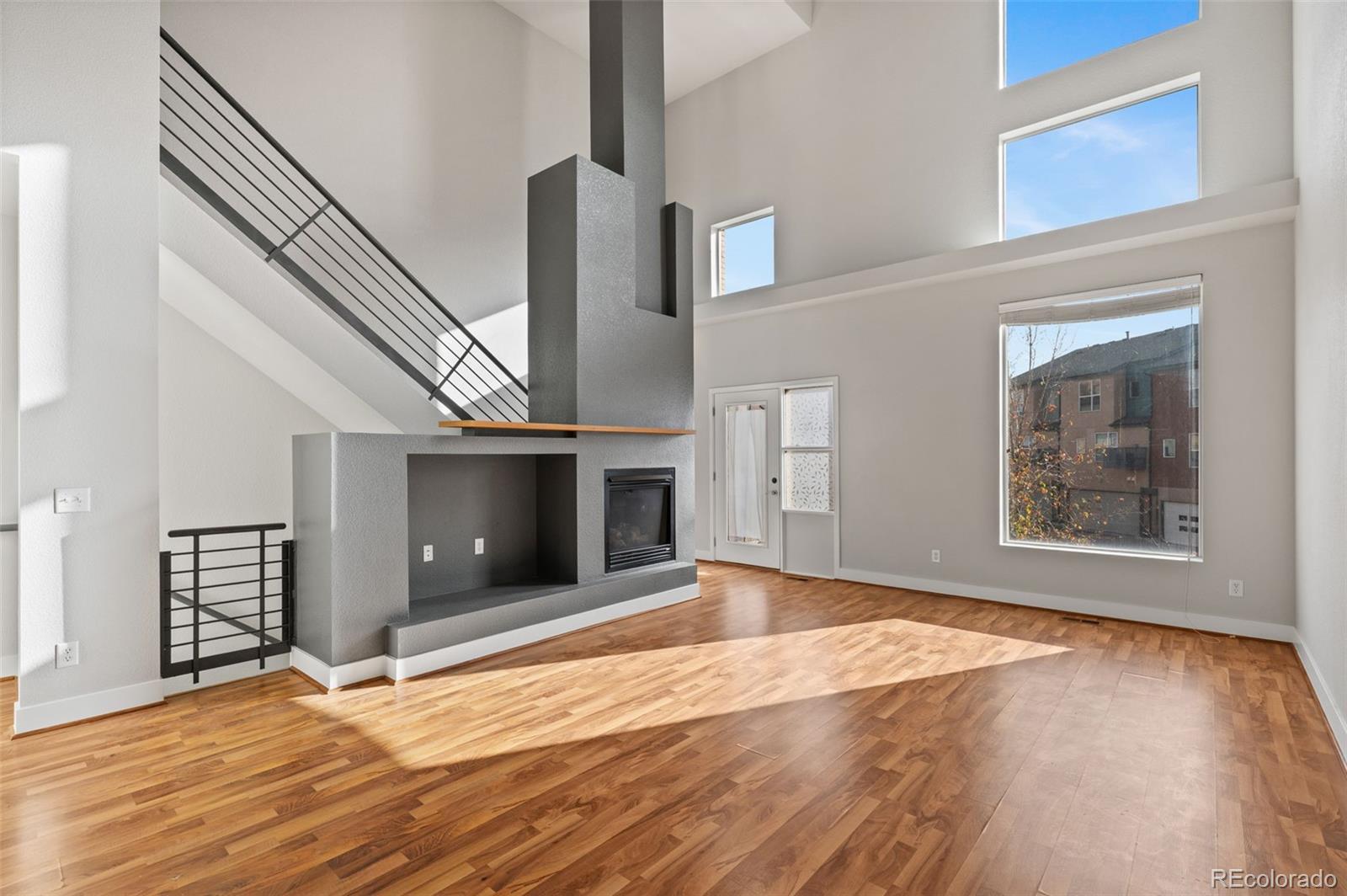 2360 South Wheeling Circle Aurora, CO 80014 - Photo 6 of 31 an empty room with wooden floor fireplace and windows