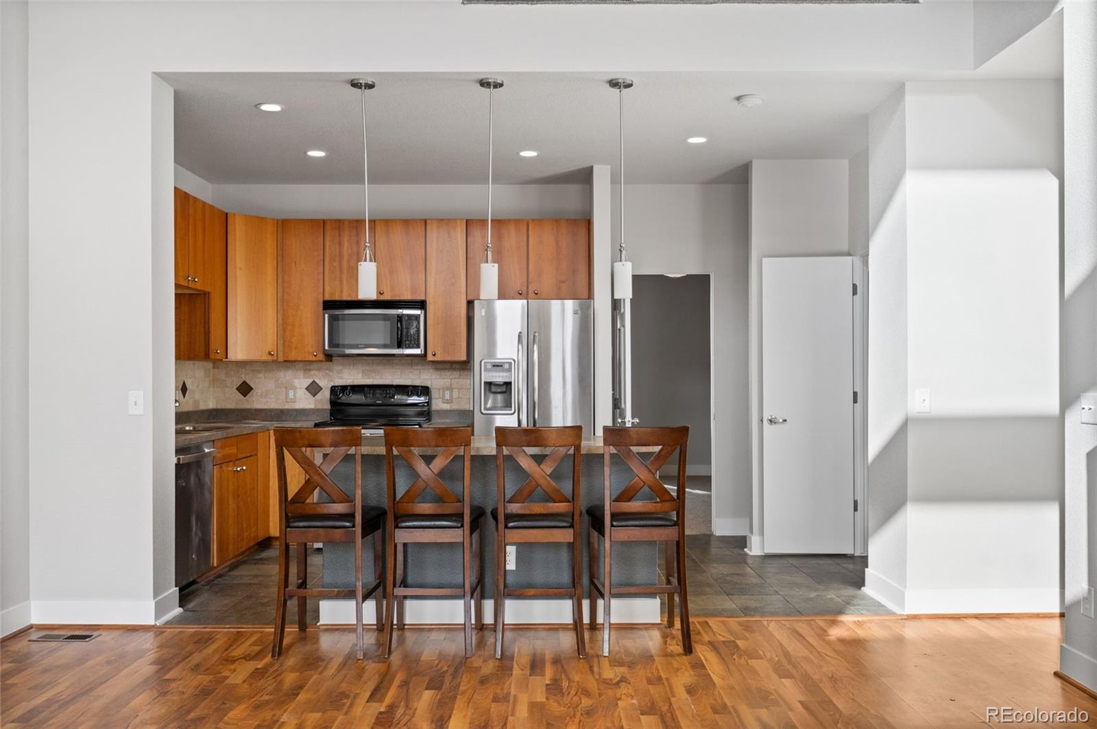 2360 South Wheeling Circle Aurora, CO 80014 - Photo 9 of 31 a kitchen with stainless steel appliances kitchen island granite countertop a refrigerator and microwave