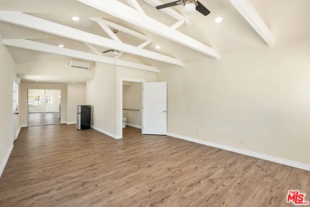 a view of a livingroom with wooden floor and stairs