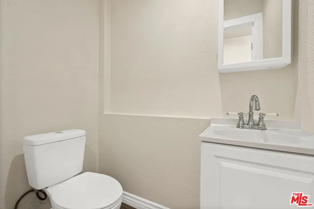 a bathroom with a toilet a sink and mirror