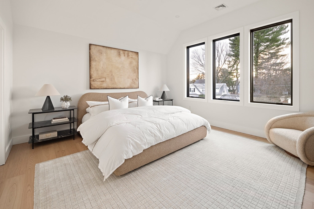 27 2nd Street Natick, MA 01760 - Photo 16 of 39 a spacious bedroom with a bed a couch and a large window with outer view