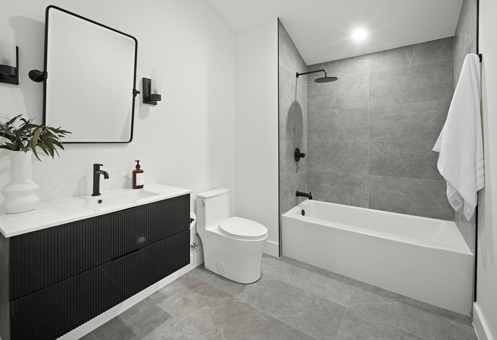 27 2nd Street Natick, MA 01760 - Photo 27 of 39 a bathroom with a bathtub shower sink vanity and toilet