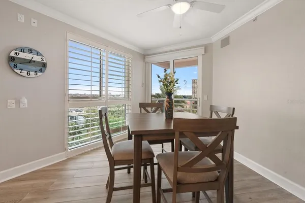 a kitchen with stainless steel appliances kitchen island granite countertop a dining table chairs and white cabinets