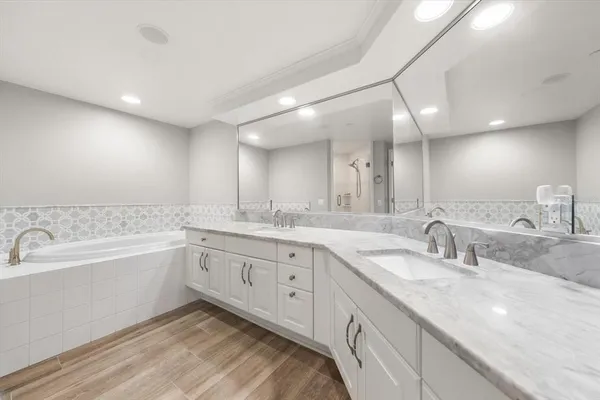 a bathroom with a double vanity sink mirror and shower