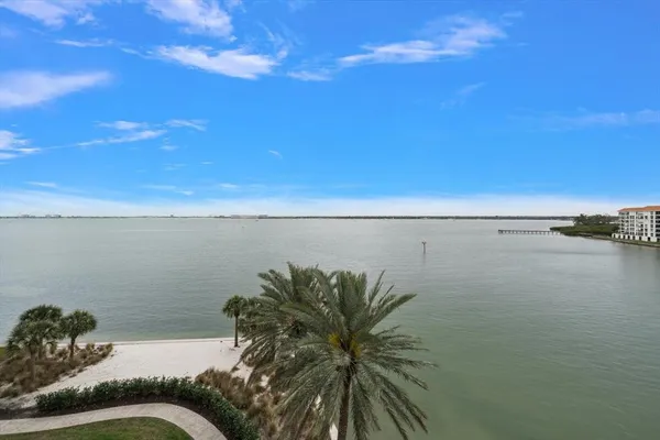 a bedroom with a bed a mirror on the dresser and a window