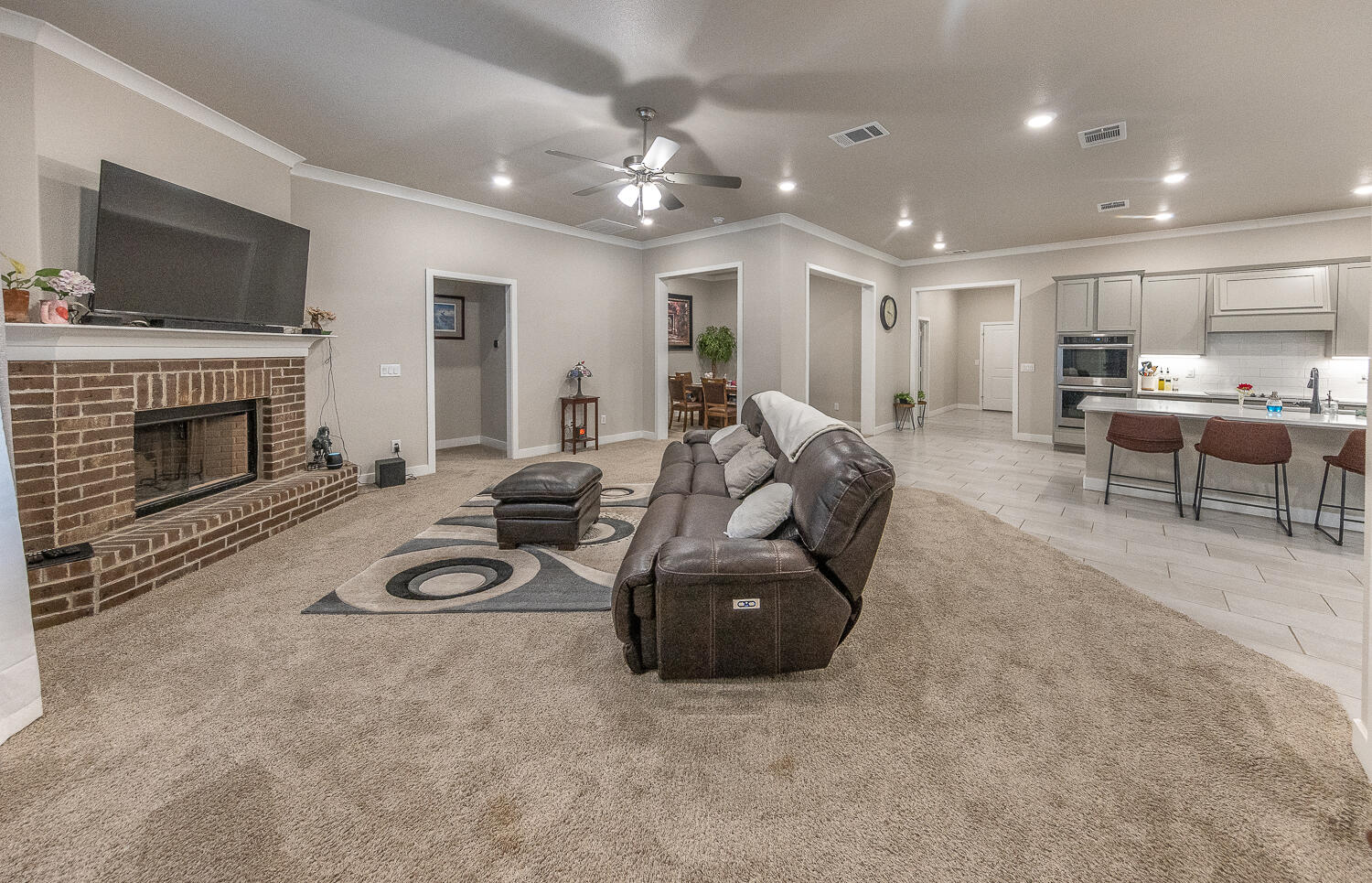 7334 29th Street Lubbock, TX 79407 - Photo 2 of 31 a living room with furniture a fireplace and a flat screen tv