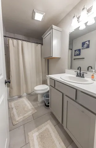 a kitchen with stainless steel appliances a table chairs refrigerator and cabinets