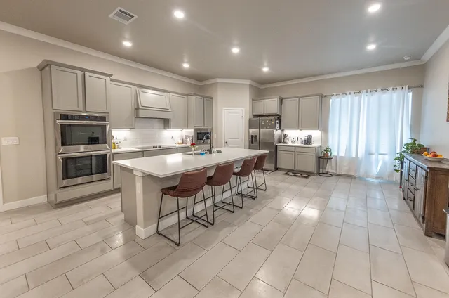 a kitchen with stainless steel appliances kitchen island granite countertop a sink and cabinets