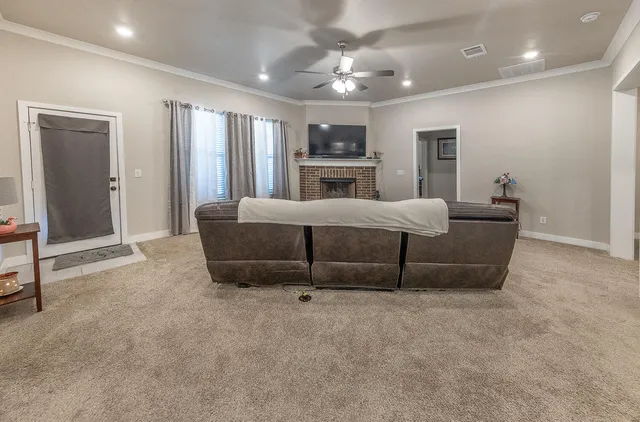 a living room with furniture and a ceiling fan