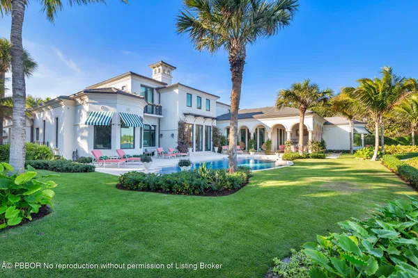 a front view of a house with a yard and potted plants