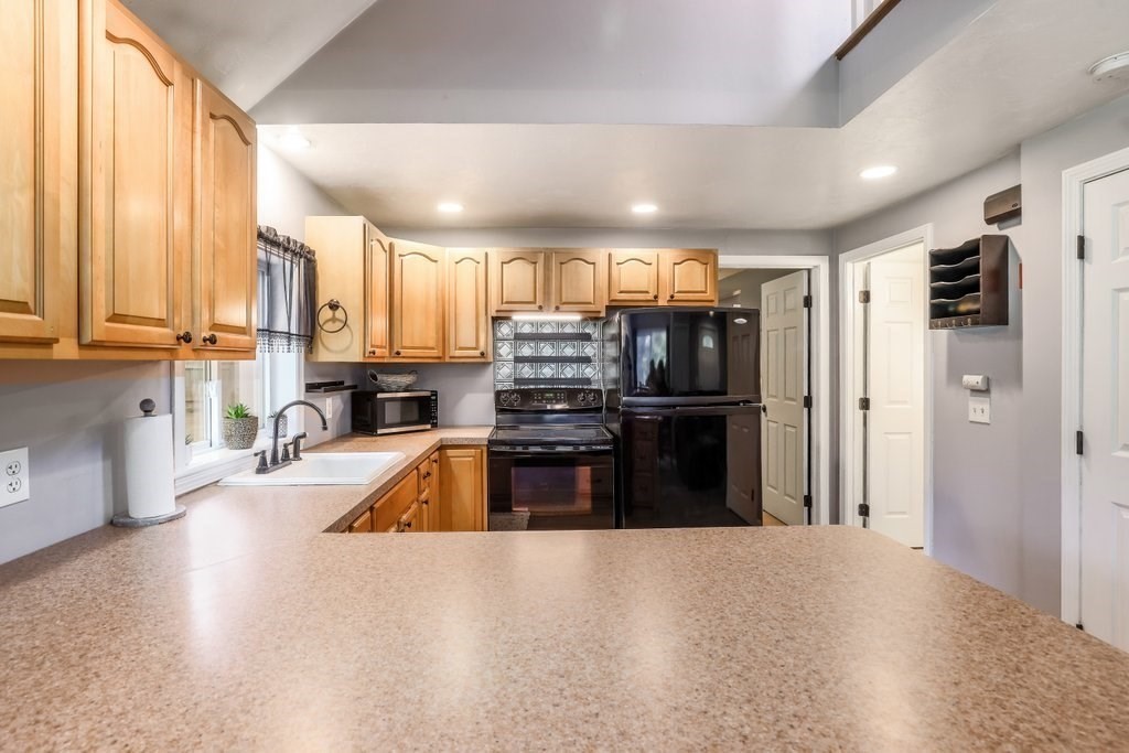 10 Bernie Road Holland, MA 01521 - Photo 6 of 29 a kitchen with kitchen island a counter top space a sink and a refrigerator
