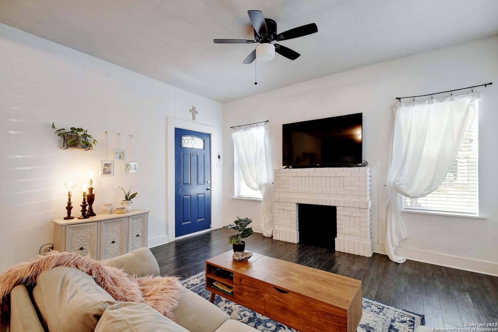 a living room with furniture a fireplace and a flat screen tv