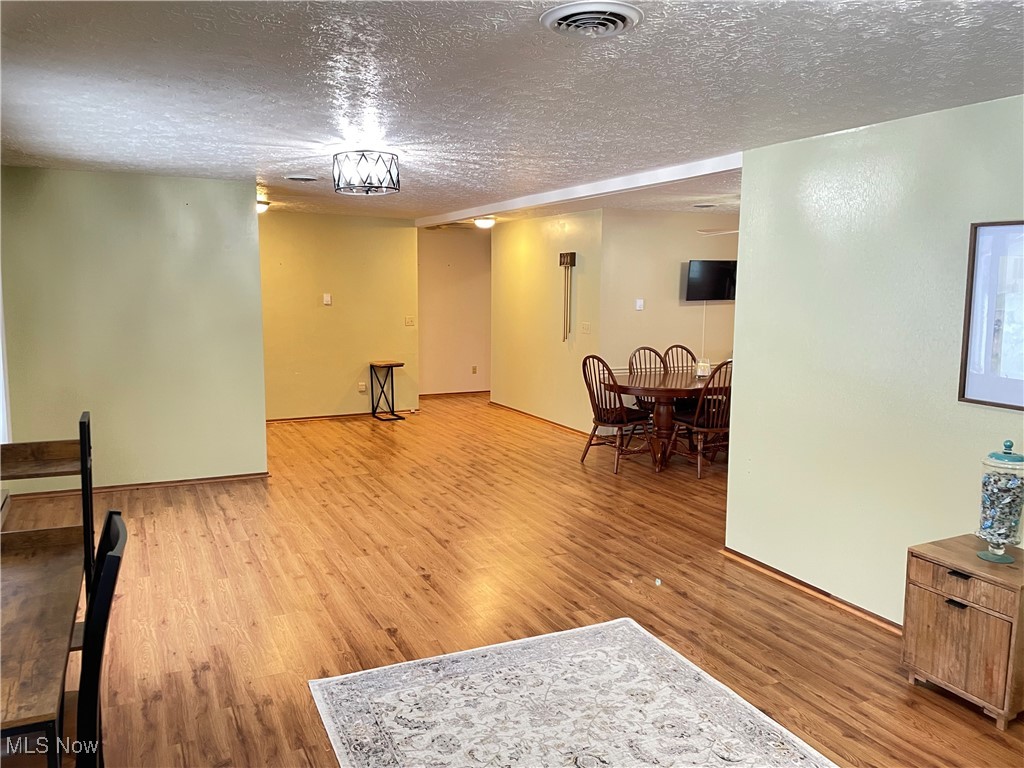 1381 Robb Road Conneaut, OH 44030 - Photo 9 of 50 Living area featuring a textured ceiling and light wood-style floors