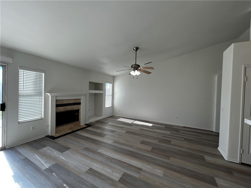 36996 Pomerol Loop Winchester, CA 92596 - Photo 2 of 5 a view of empty room with a fireplace and wooden floor