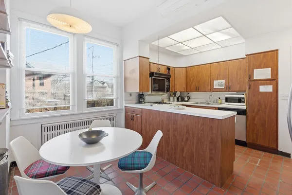 a kitchen with stainless steel appliances granite countertop a sink a stove a kitchen island with chairs and table