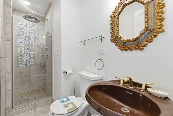 a bathroom with a sink a toilet and shower