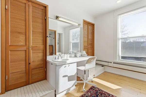 a bathroom with a sink a mirror and next to a window