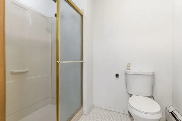 a white toilet sitting next to a shower