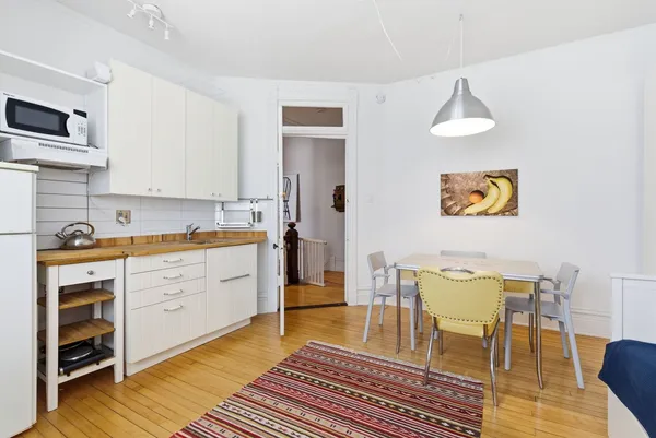 a room with wooden floors and a view of bedroom