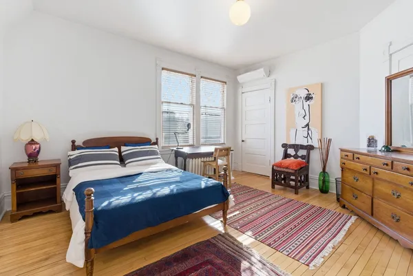 a bedroom with a bed and wooden floor
