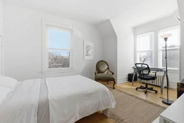 a bedroom with a bed and large windows