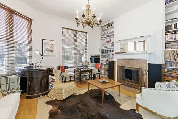 a living room with furniture a chandelier and a fireplace