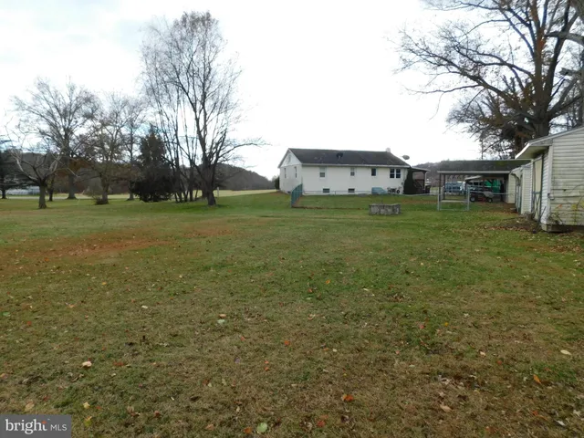 a view of a large house with a big yard and large trees